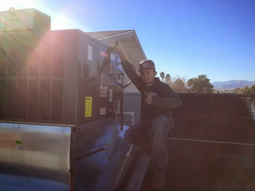 HVAC technician performing Air Duct Cleaning on a rooftop unit in Connerton